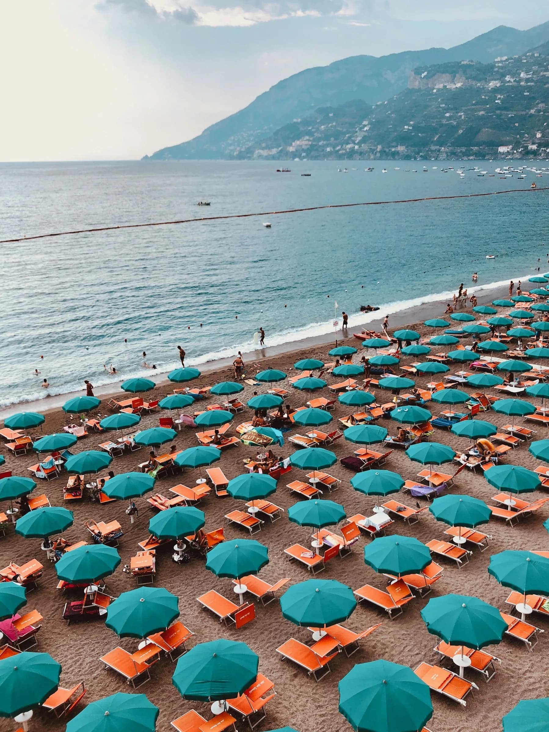 Green umbrellas on the Maiori beach, the coast running towards Minori