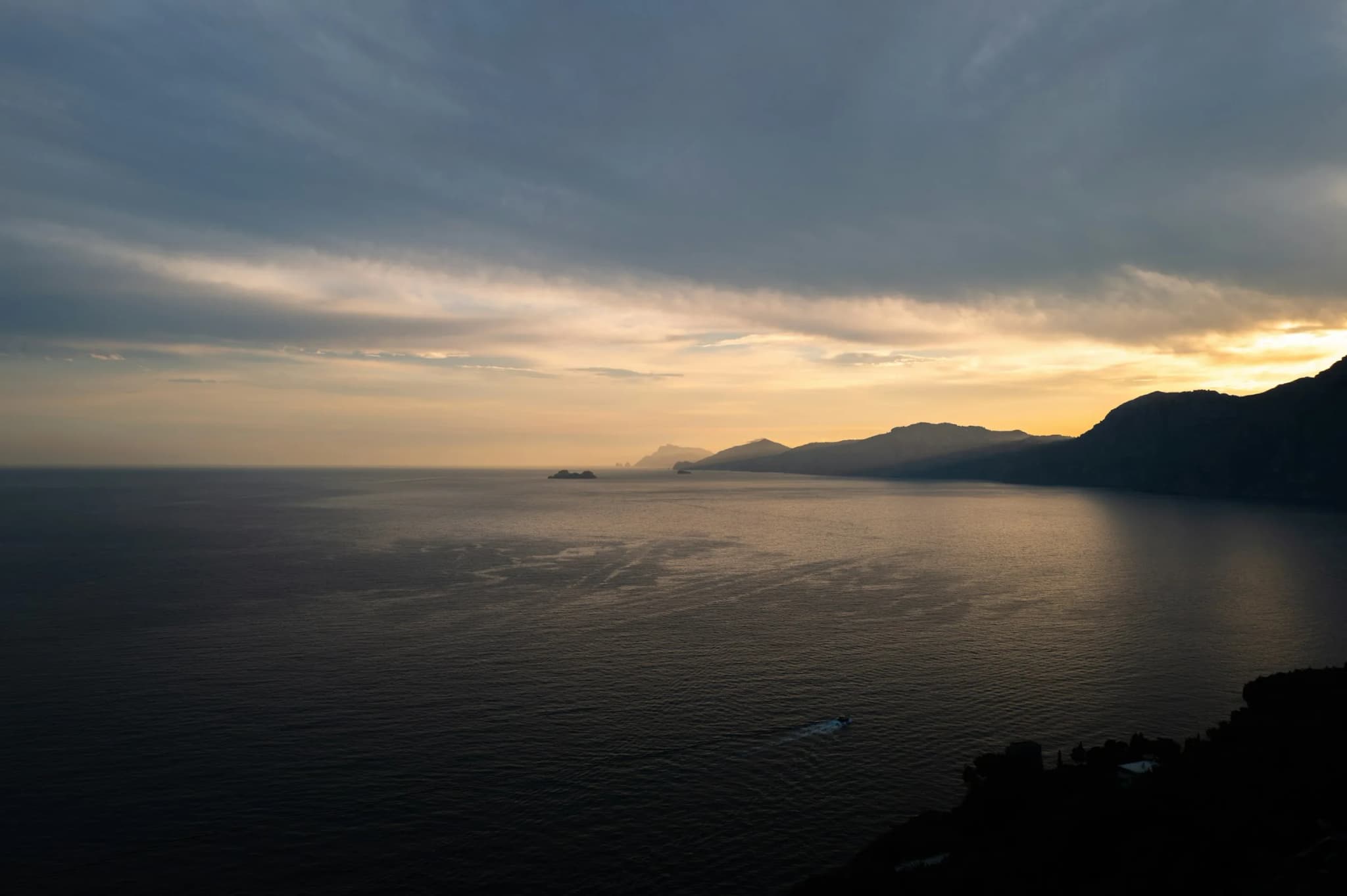Sunset from the Praiano shore, the sun low on the water