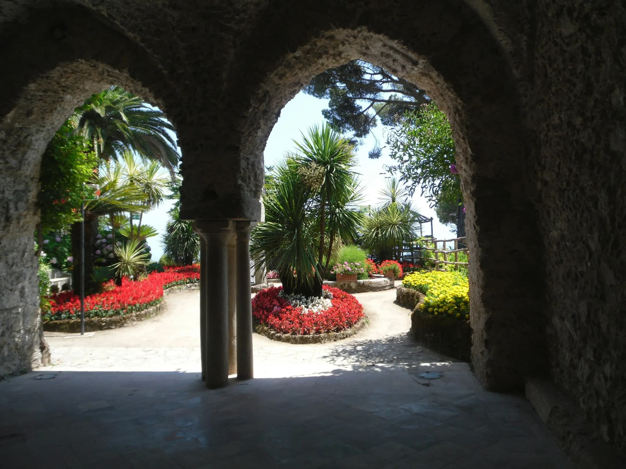 The garden of Villa Rufolo seen through two stone arches