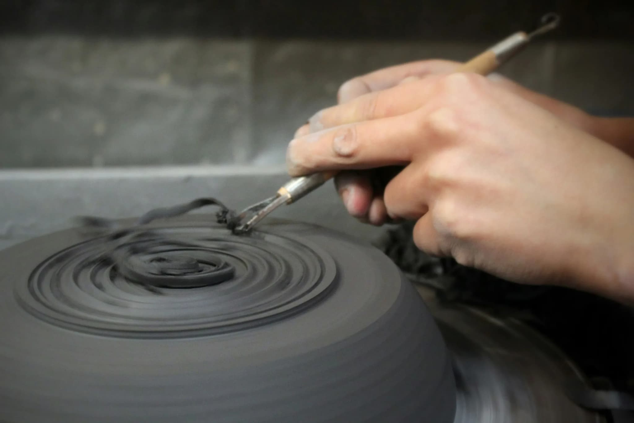 A brush drawing a spiral on a plate on the wheel