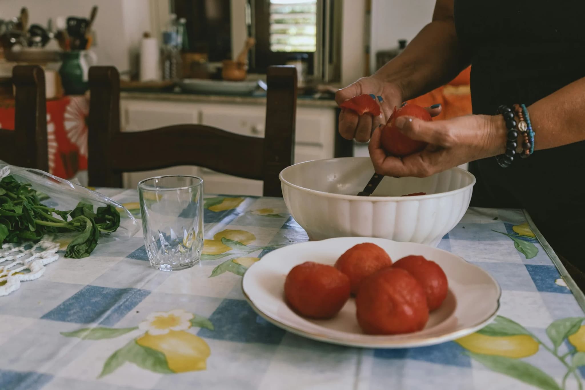 Tomatoes and basil on a checked tablecloth, ready for the sauce