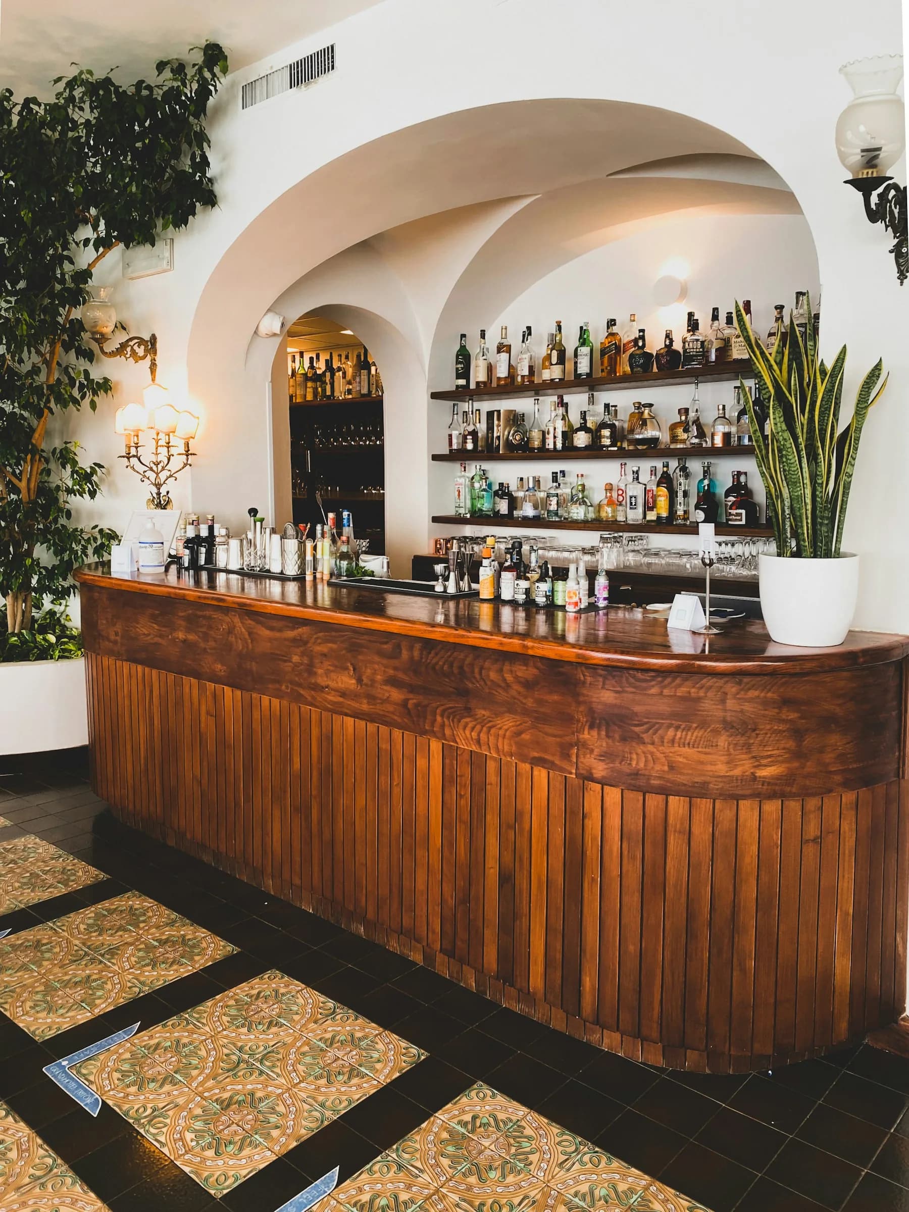 Il bancone di legno di un bar sotto una volta bianca