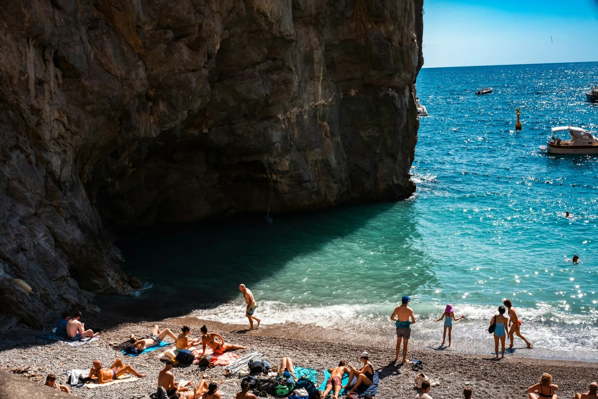A small beach in a cove under the rock, the water clear