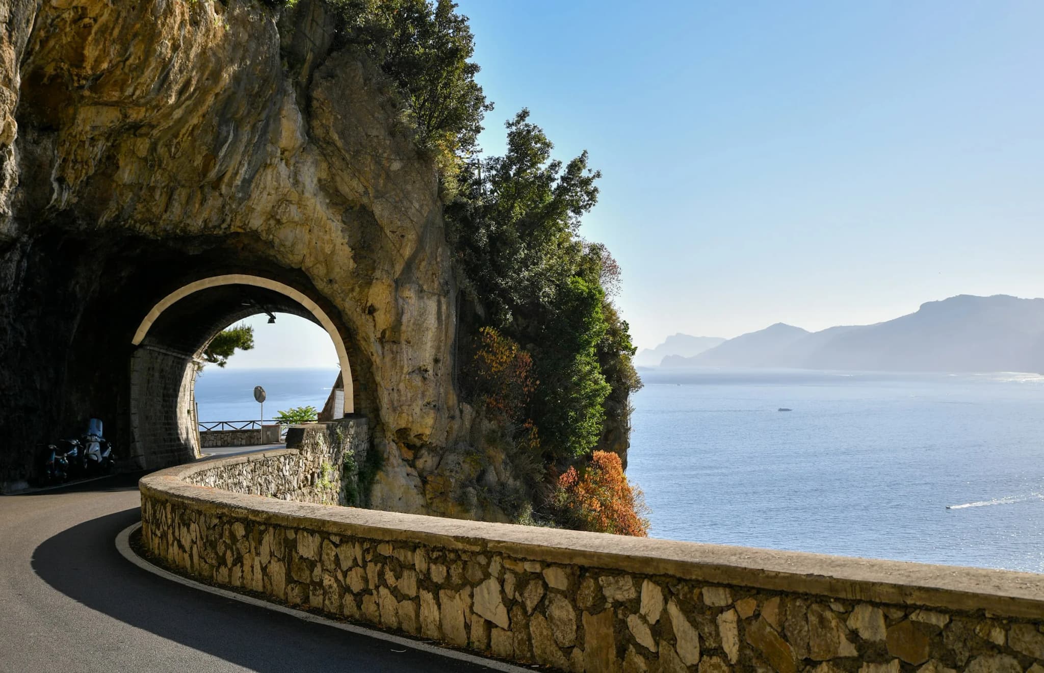 The coast road running through a rock tunnel above the sea